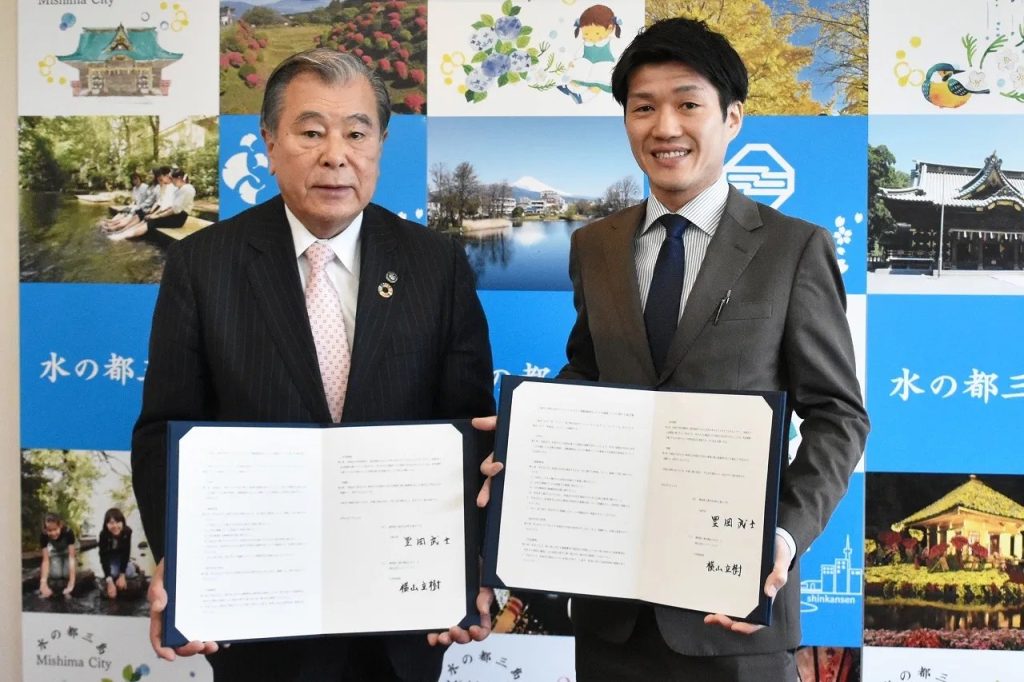 三島市長と協定書を手に記念撮影する院長 横山立樹